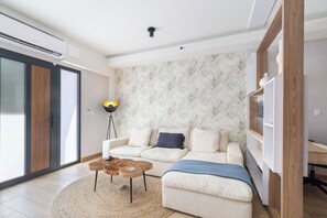 Ein stilvolles Wohnzimmer mit Sofa, Couchtisch und Stehlampe.