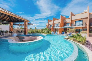 Ein Hotel mit Schwimmbad, Außenbereich und überdachter Terrasse.