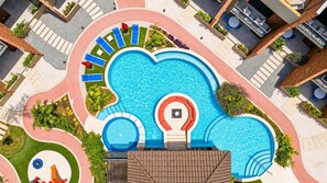 A rooftop pool with multiple sun loungers and a small hot tub.
