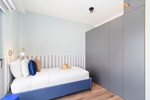 Ein Schlafzimmer mit einem Bett, Nachttischlampen und einem Kleiderschrank.