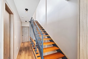 Un intérieur moderne avec un escalier en bois et une porte.