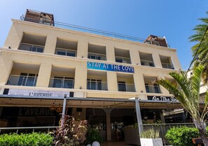 Ein mehrstöckiges Gebäude mit einem Schild, auf dem „STAY AT THE COVE“ und „BELGIAN L'AVENIC“ im Erdgeschoss steht.