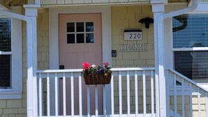 A house with a front porch, a door labeled "220 HOME", and a mailbox.