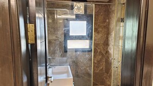 A modern bathroom with a glass-enclosed shower, a built-in sink, and a window. - Hotel Spot Inn Paharganj Near New Delhi Railway Station (New Delhi)