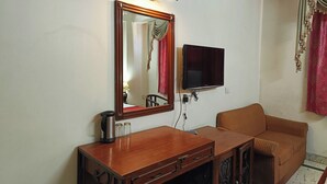 A room with a wooden desk, a television, and a sofa. - Hotel Spot Inn Paharganj Near New Delhi Railway Station (New Delhi)