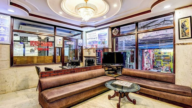A lobby with a brown leather sofa, a glass coffee table, and a chandelier. - Hotel Spot Inn Paharganj Near New Delhi Railway Station (New Delhi)