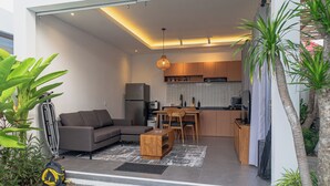 A modern open-plan living area with a sofa, coffee table, and dining table. - Cypress Villa (Ungasan)