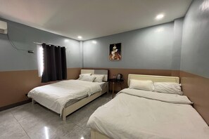 A hotel room with two beds, a small table, a wall-mounted artwork, and a window with curtains. - Qingqing Hotel Pasay Manila near MOA (Pasay)