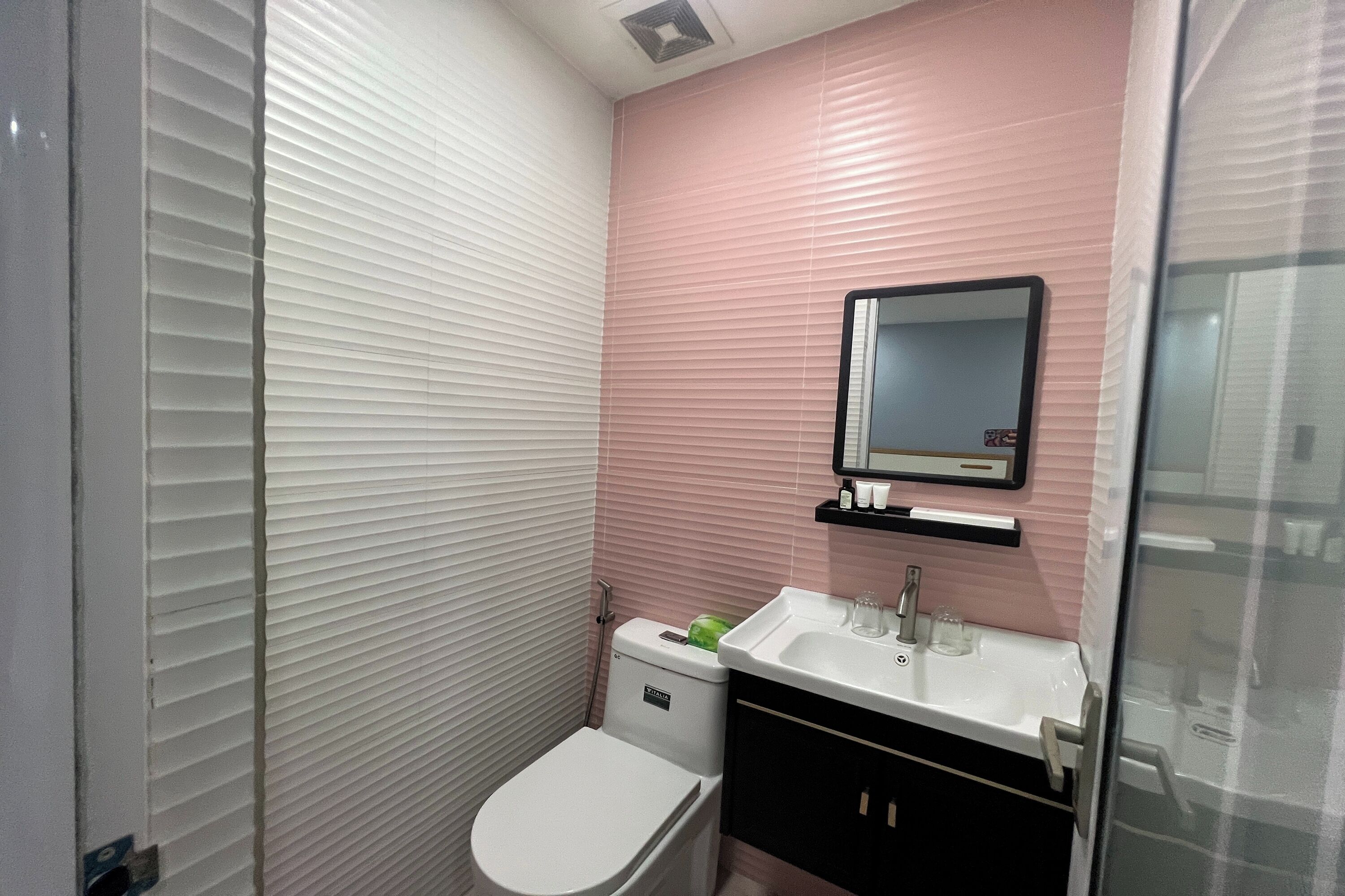 Une salle de bain avec des toilettes, un lavabo et un miroir.