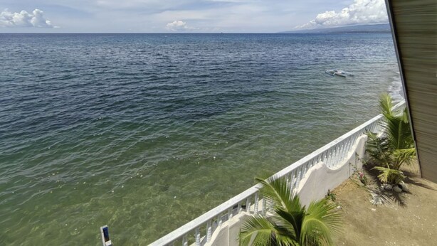 A view of a body of water with a clear sky and a distant landmass. - Sea Breeze Beachfront Villa Cebu (Argao)