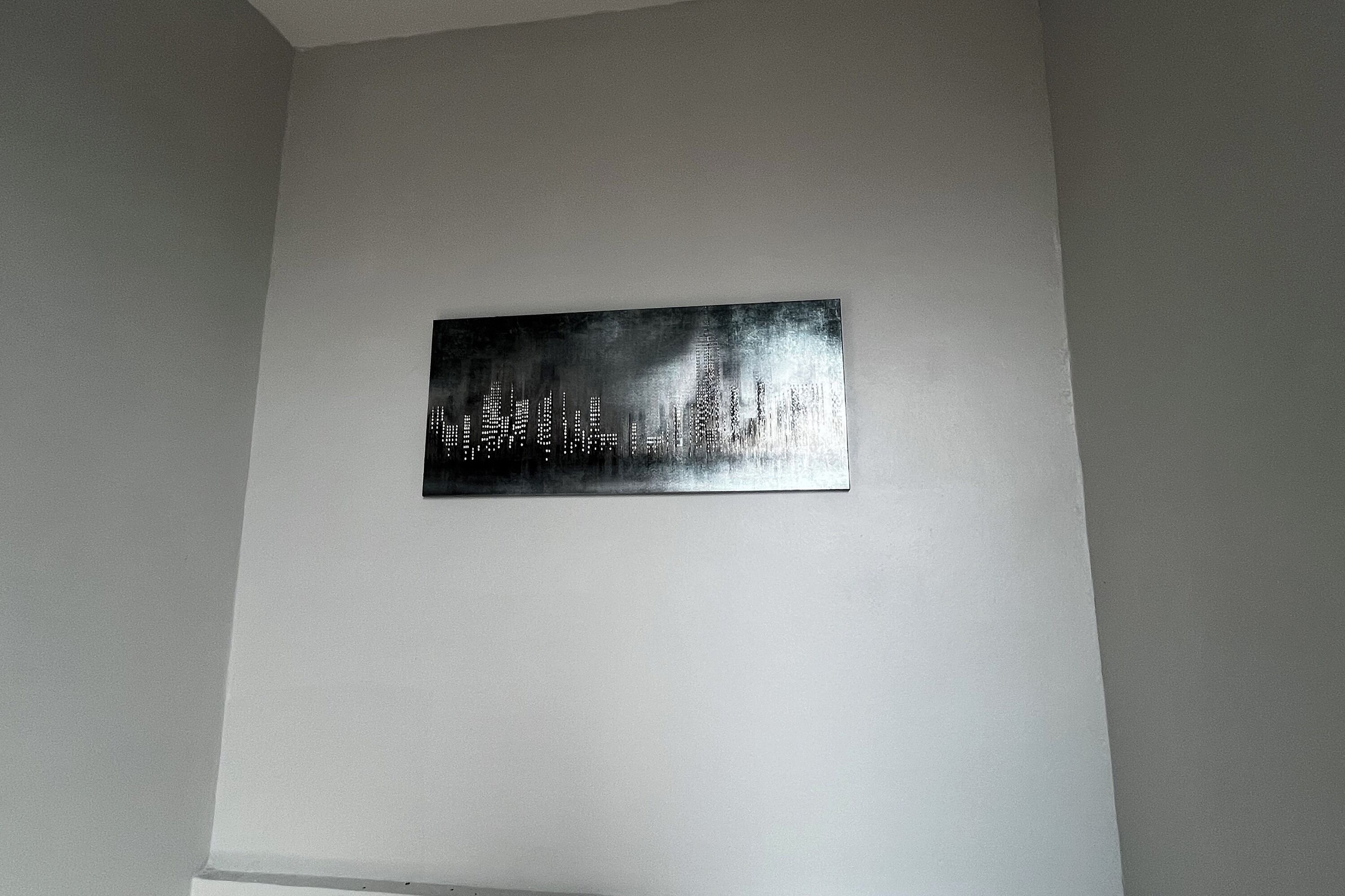 Una obra de arte metálica sobre una pared lisa.