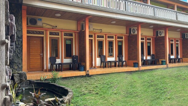 A hotel with a covered outdoor seating area, multiple air conditioning units, and a small water feature. - Family 24 Hotel near Pantai Cipatujah (Cipatujah)