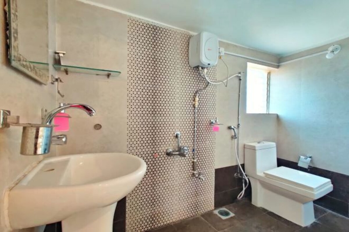 Un baño con lavamanos, inodoro y ducha.