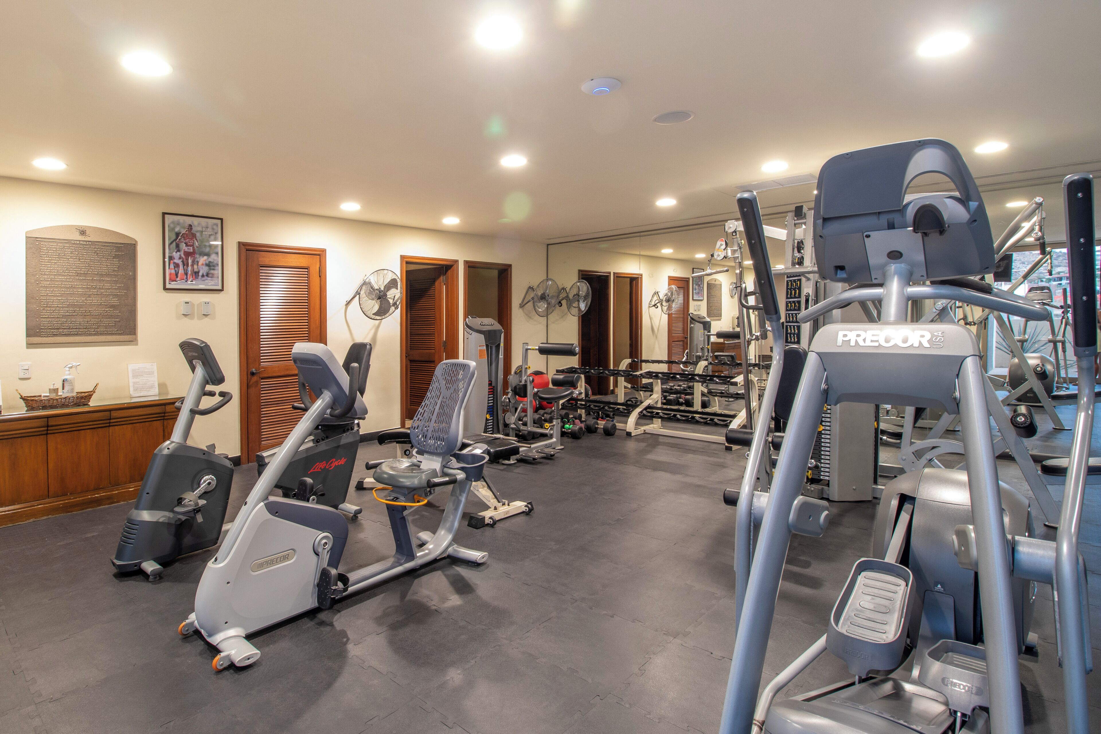 Un gimnasio con equipo de ejercicio diverso, incluyendo cintas de correr y máquinas de pesas.