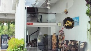 A modern building with a glass entrance, a reception desk, and a sign for 'Seed Boutique'. - Seed Resort (Shrirangapattana)