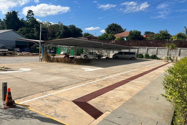 A parking area with marked spaces, a covered structure, and a building in the background. - My Memory Mueang Loei (Mueang Loei)