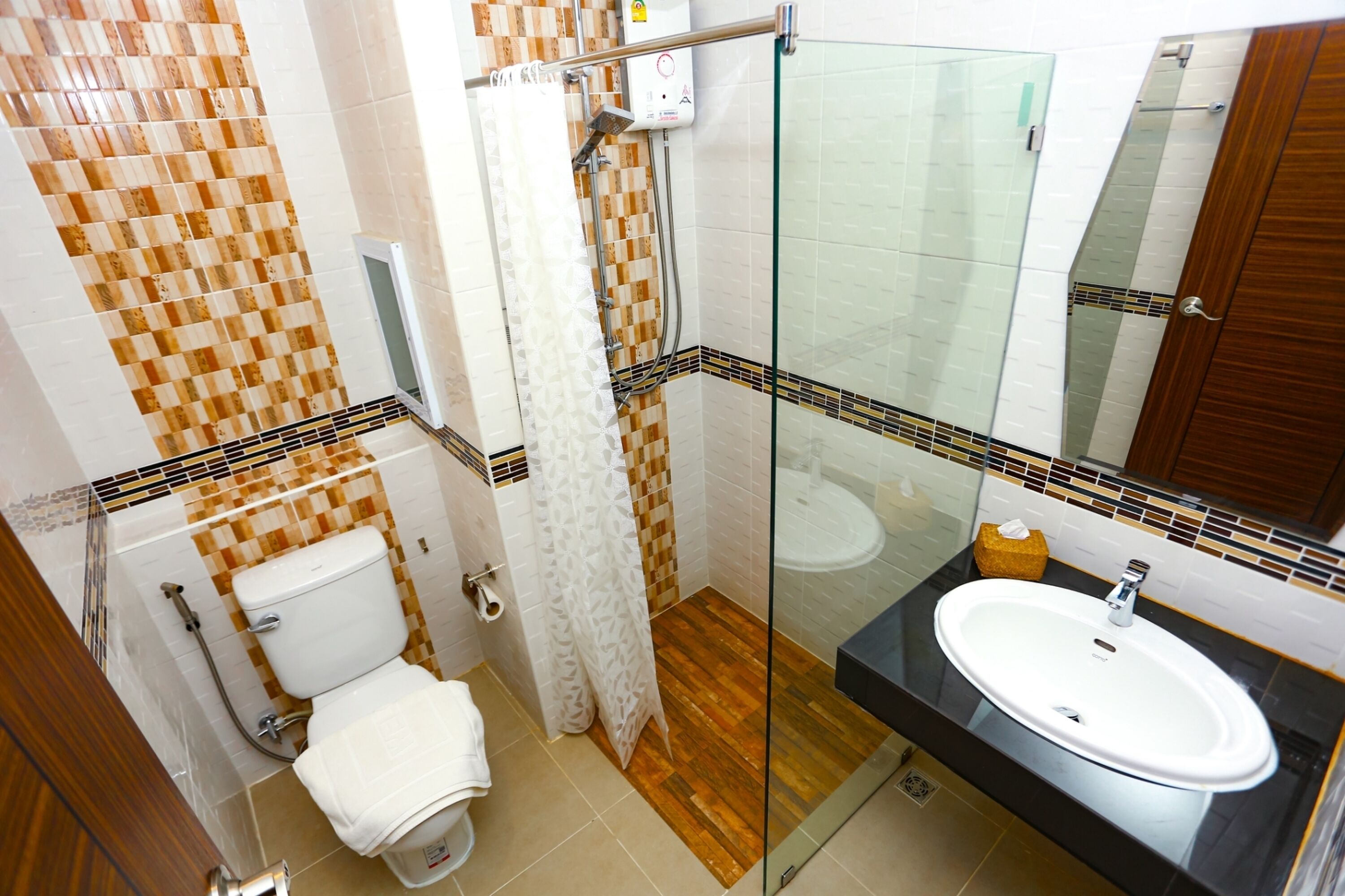 A bathroom with a toilet, shower, and sink.