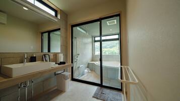 A modern bathroom with a large mirror, a sink, a shower, and a bathtub.