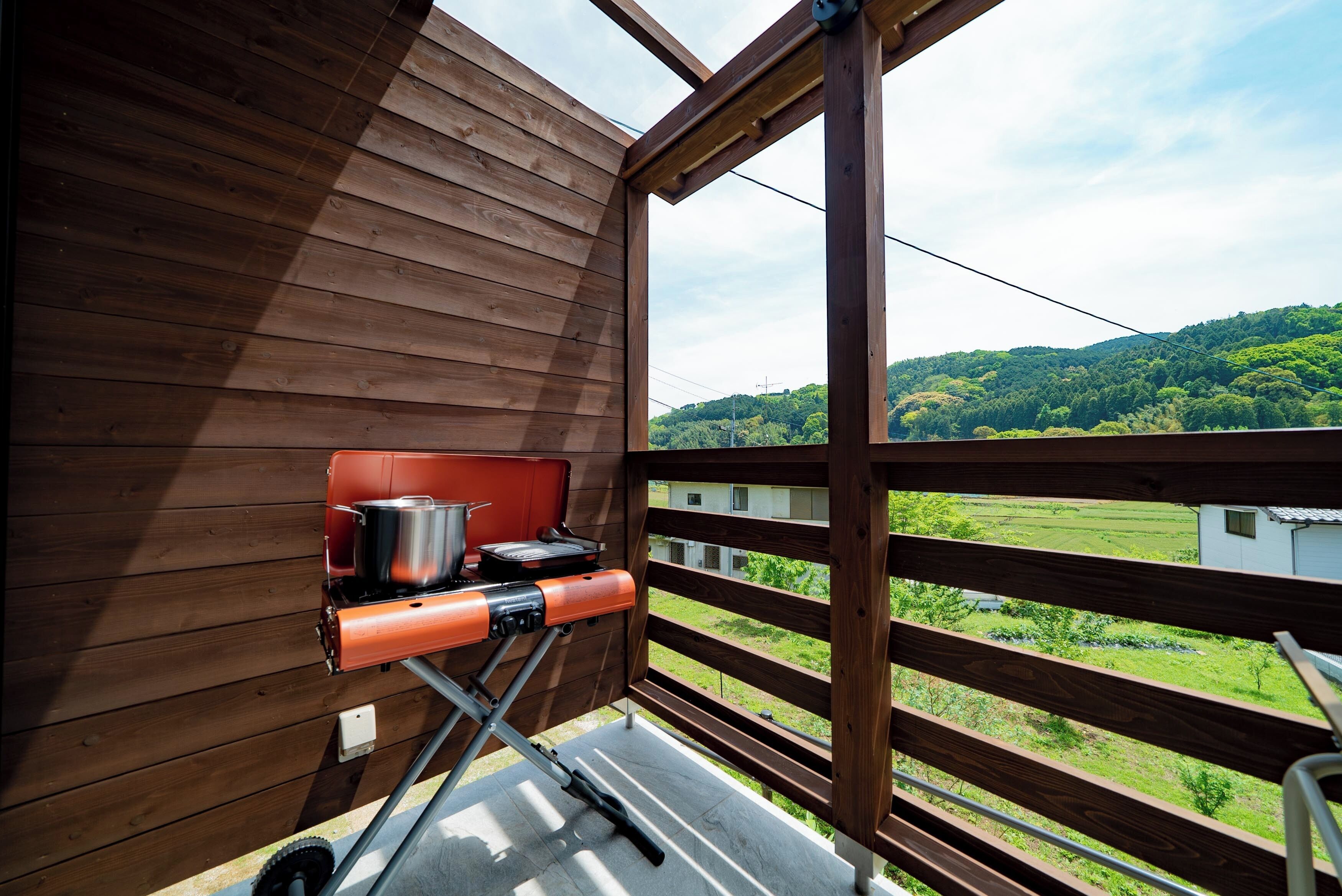 Ein Holzbalkon mit Grill und Kochgeschirr.