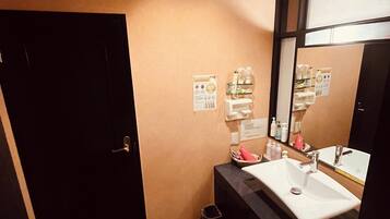 A bathroom with a sink, mirror, and toiletries.