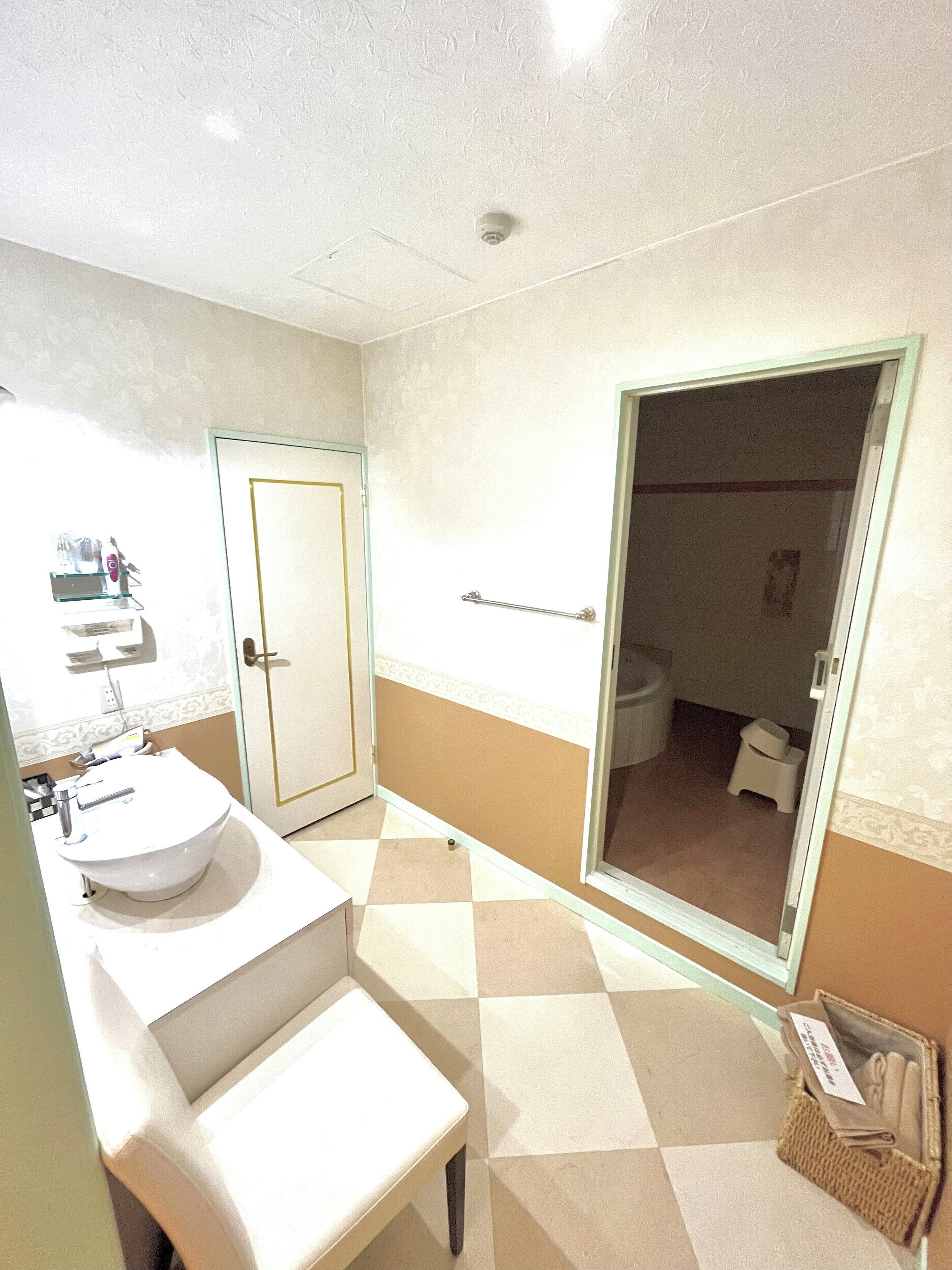 A bathroom with a sink, toilet, and shower area.