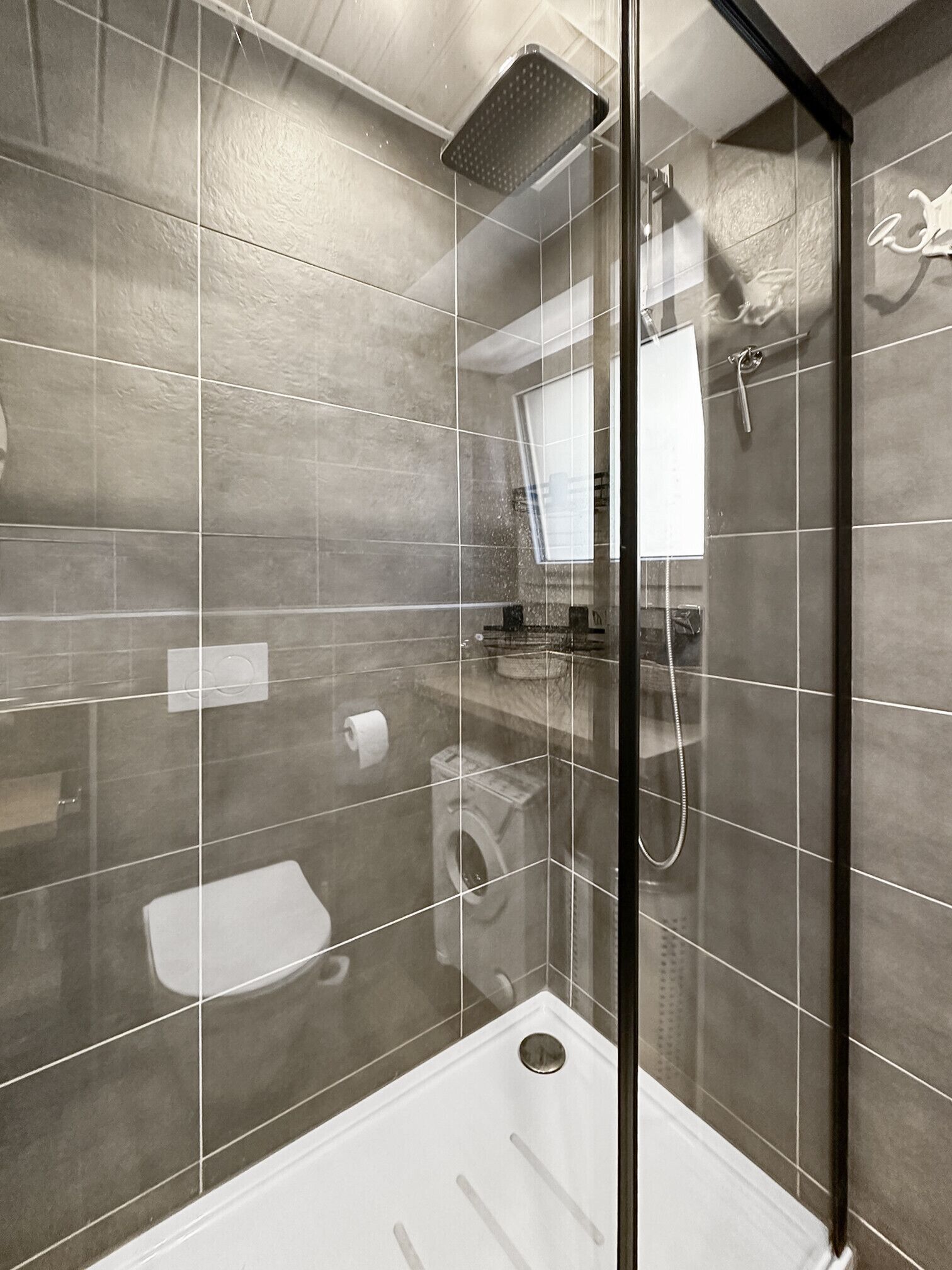 Ein modernes Badezimmer mit einer Duschkabine, Toilette und Waschbecken.