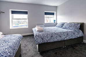 A bedroom with a bed, a window, and a radiator.