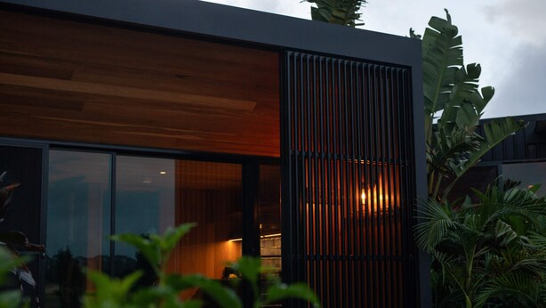 A modern building with large windows and a wooden facade. - Three One Bedroom Cabins (Bangalow)