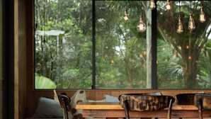 A wooden dining table with chairs, a bench, and hanging light fixtures. - Balaka Exclusive Property (Bangalow)