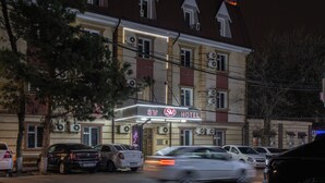 A hotel with a classic architectural style, featuring a prominent marquee sign, multiple air conditioning units, and a parking area with several cars. - SV Stable Visitor Hotel (Tashkent)