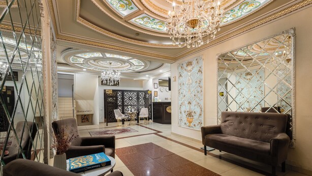 A spacious lobby with a chandelier, a sofa, and a coffee table. - SV Stable Visitor Hotel (Tashkent)
