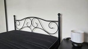 A bed with a black headboard, a bedside table with a lamp, and a picture on the wall. - 10a05 Apartamento 2 dormitorios vistas al parque (Pravia)