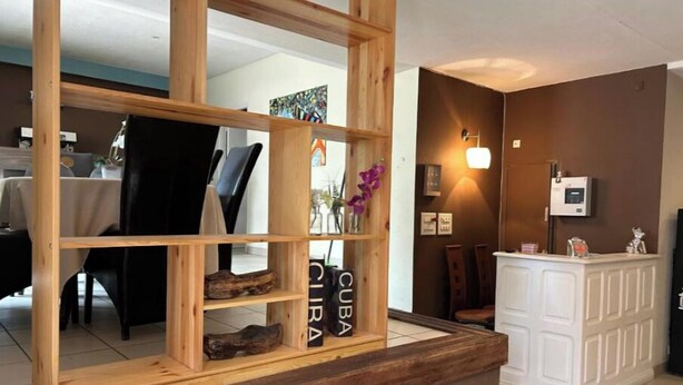 Un espace d’accueil avec un bureau en bois, un comptoir blanc et un luminaire fixé au mur.