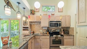 A kitchen with wooden cabinets, a stainless steel oven, and a granite countertop.