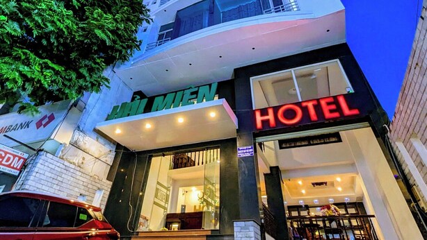 Un hotel con fachada moderna, varios pisos y una entrada visible con escalones.