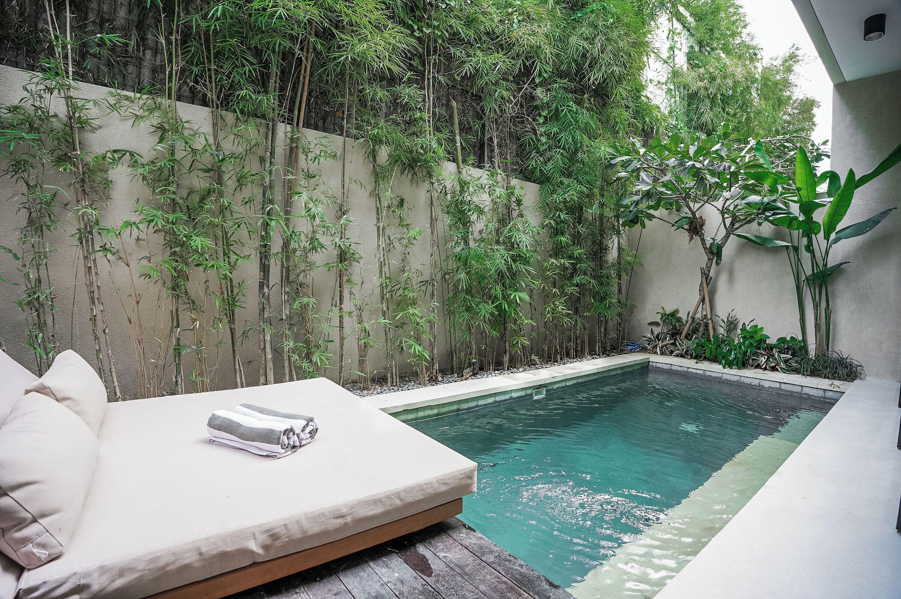 A poolside area with a lounge chair and a small pool.
