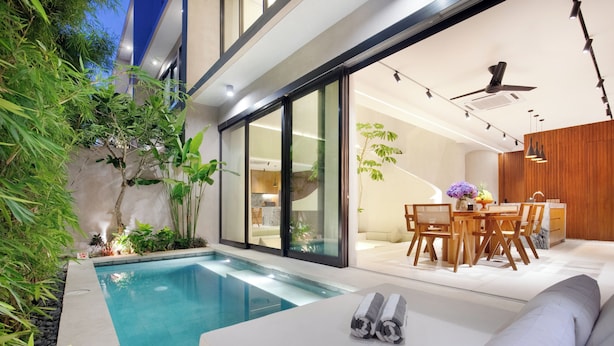 A modern outdoor pool area with a dining set and a sofa. - Suave Villa Canggu (Canggu)