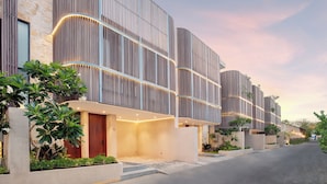A modern building with vertical wooden slats, a central entrance, and a street view. - Suave Villa Canggu (Canggu)