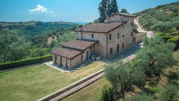 A stone building with a tiled roof, a small patio with chairs, and a view of the surrounding countryside. - Casolare Torre With Pool And Ac (Poggibonsi)