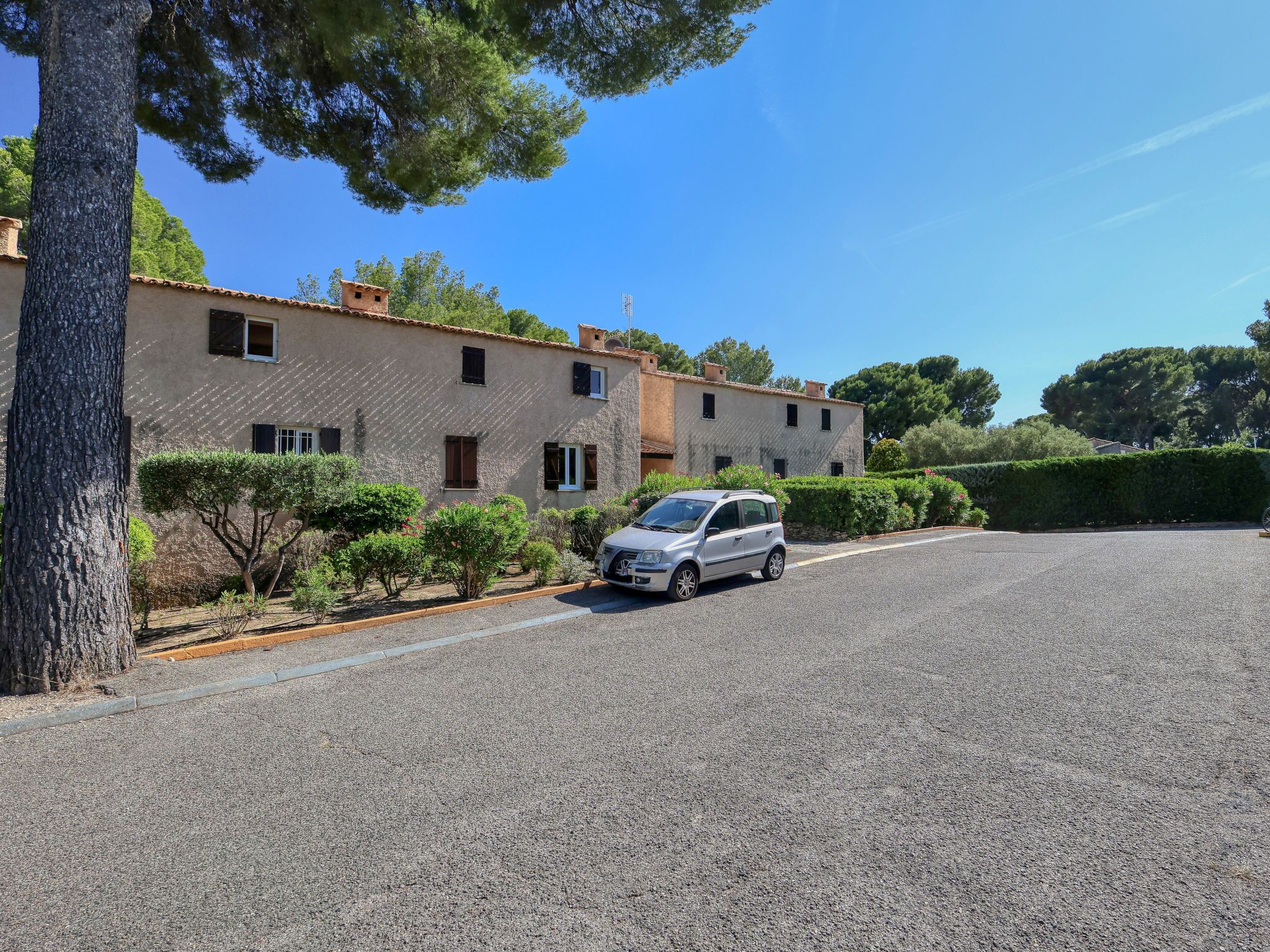 A residential building with a car parked in front.