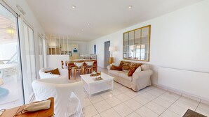 A modern living room with a sofa, coffee table, and dining area.