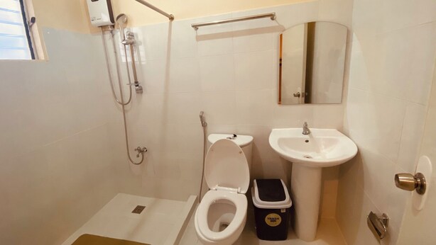 Un baño con inodoro, lavamanos y ducha.