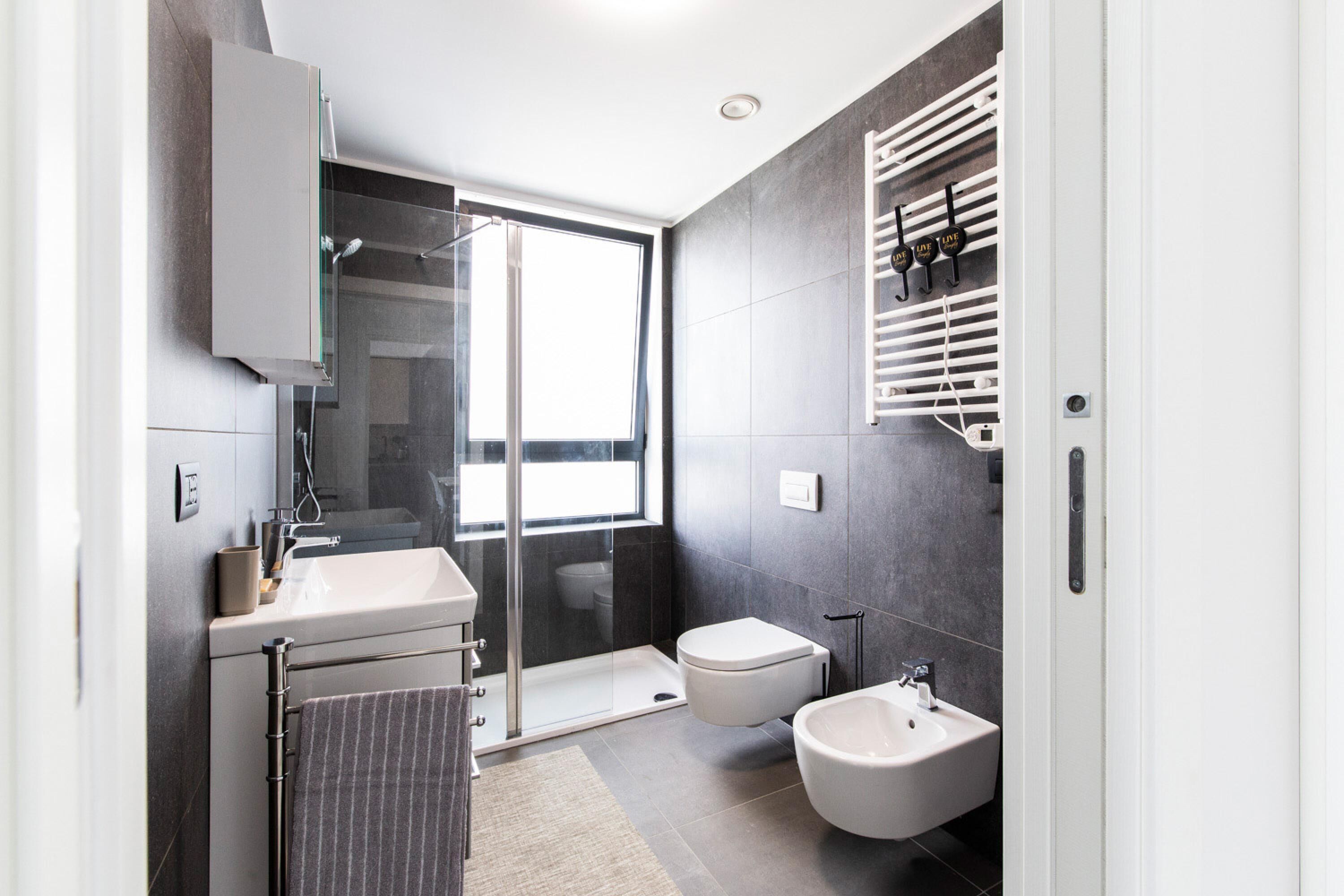 Une salle de bain moderne avec une douche à parois de verre, des toilettes, un bidet et un lavabo.