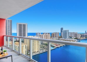 A balcony with a view of a cityscape, a marina, and the ocean. - Infinite View, Amazing Apt, Spectacular Amenities (Hallandale Beach)