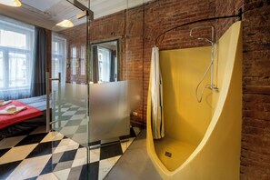 A modern bathroom with a large bathtub, a glass shower enclosure, and a checkered floor.