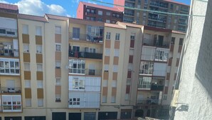 Un edificio residencial de varios pisos con balcones y un área de estacionamiento debajo.