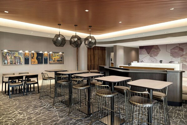 A modern restaurant with multiple tables and chairs, a wooden ceiling, and contemporary artwork on the walls. - SpringHill Suites® by Marriott® Easton Bethlehem (Easton)