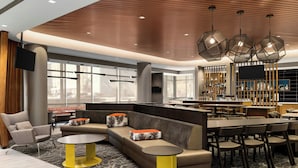 A modern hotel lobby with a bar area, seating arrangements, and large windows. - SpringHill Suites® by Marriott® Easton Bethlehem (Easton)