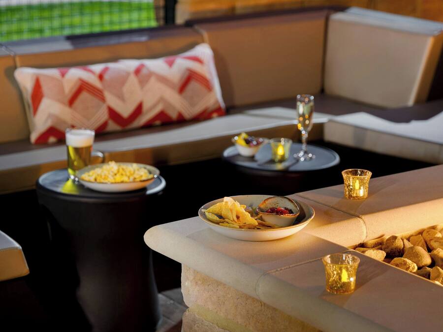 Un comedor con un sofá, una mesa con platos de comida, vasos y velas.