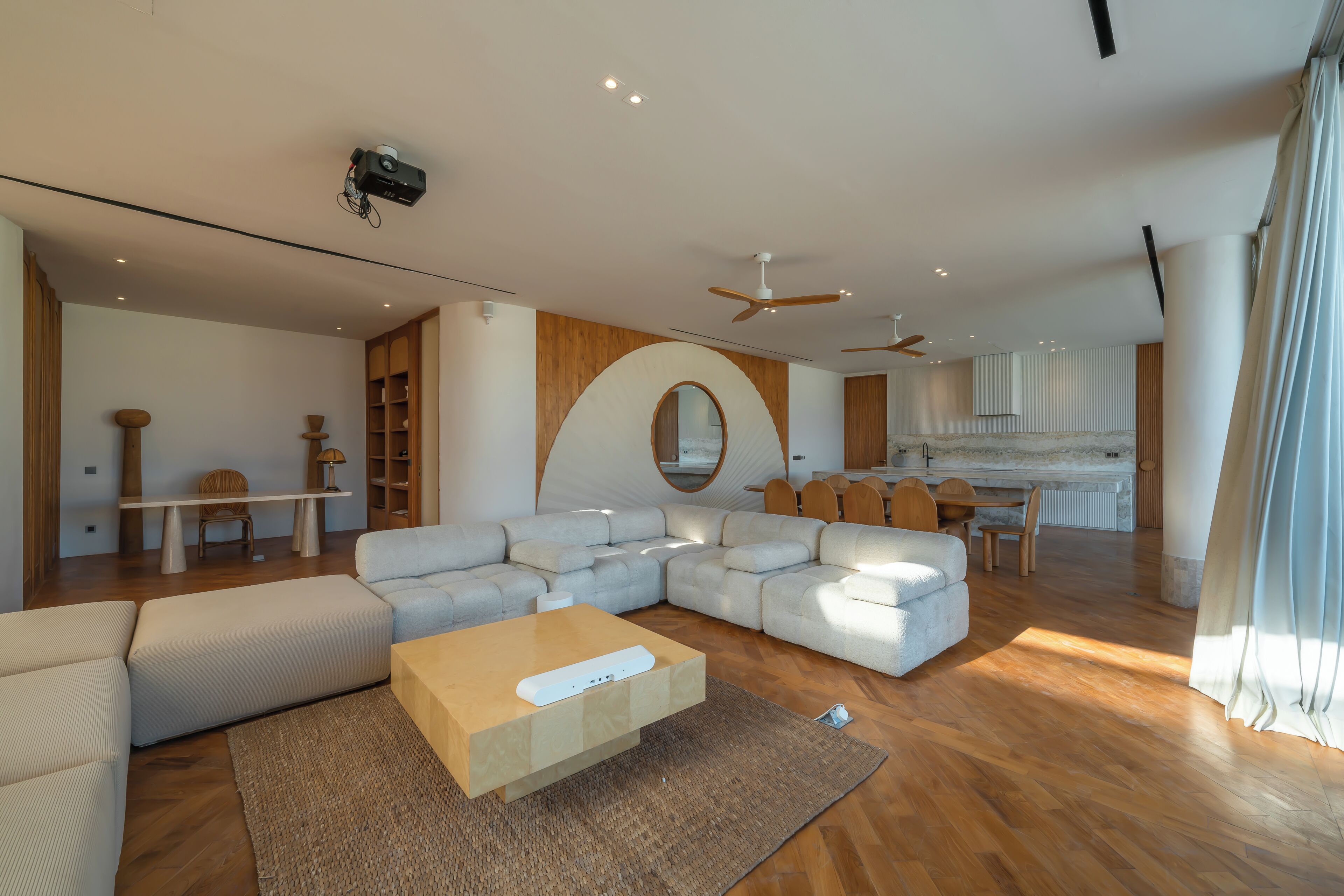Una sala de estar moderna con un sofá seccional, una mesa de centro y un comedor con mesa y sillas.